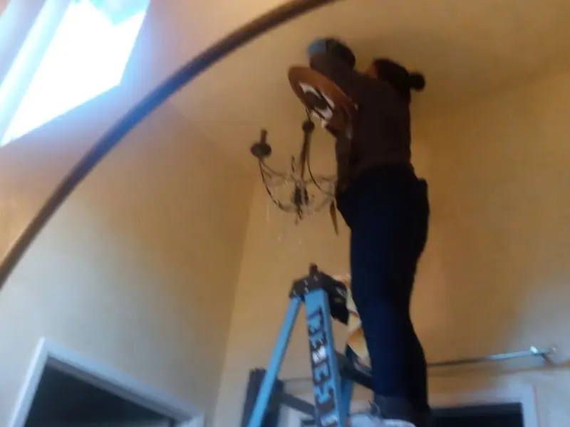 Electrician installing a chandelier in a Watsonville residence